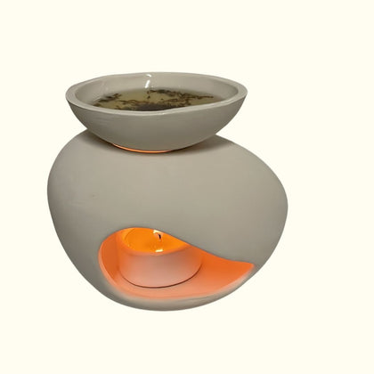 Handcrafted ceramic wax burner with an organic, elegant shape with a pearl background. Paired with a small tealight and natural wax melts for home ambiance.